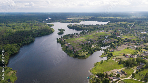 Aerial view of a small river with trees and houses on the shore