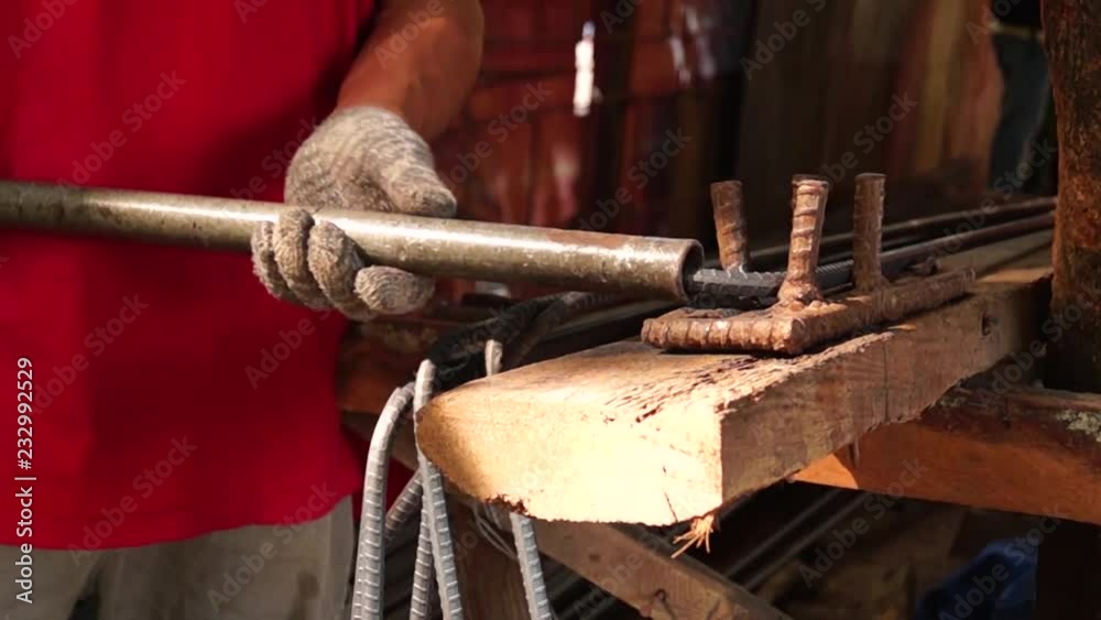 Steelworker manually bends iron bar Steelworker manually bends iron bar