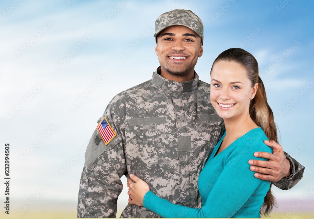 Smiling soldier with his wife standing against background Smiling soldier with his wife standing against background