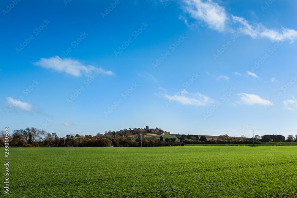Small church on hill with big sky and green fields