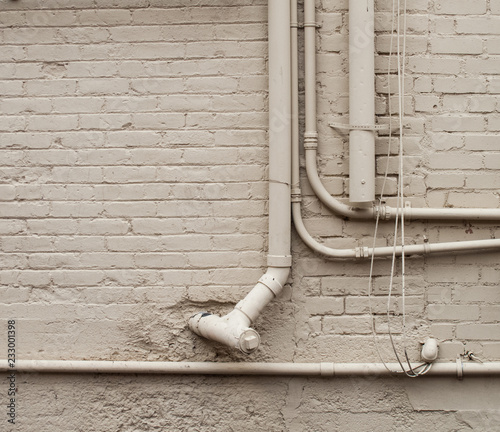 White brick wall with white pipes