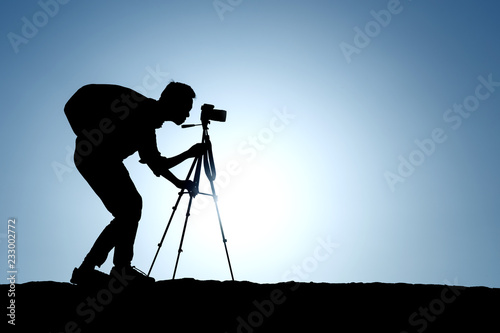 A silhouette of a photographer with a tripod