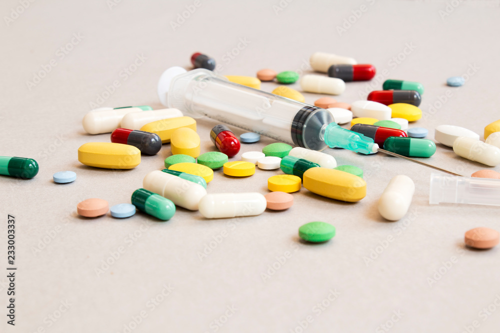 various drugs, tablets and needles, background.