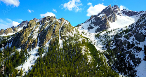 Sawtooth Mountains, Idaho, USA - Aerial View Of Jagged Snowy Peaks With Pine Trees On The Slopes