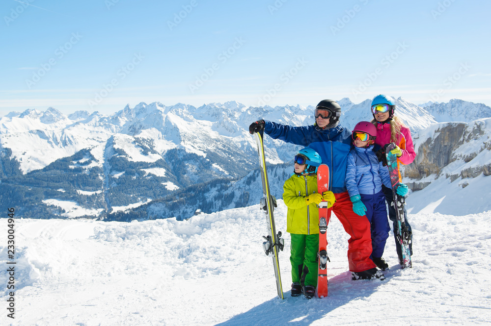 Happy family enjoying winter vacations in mountains . Ski, Sun,Snow and fun. - obrazy, fototapety, plakaty 