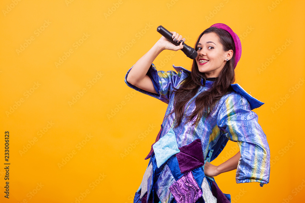 Beautiful young woman wearing funky clothes and singing microphone. Having fun Beautiful young woman wearing funky clothes and singing microphone. Having fun