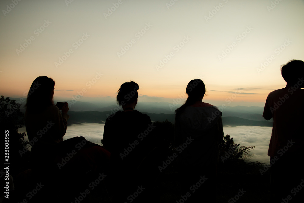 Silhouette of tourists in a high mountain valley with sunrise in the morning.