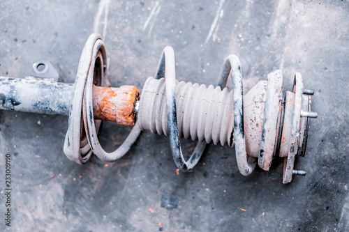 A closeup of a stand of an old car shock absorber.