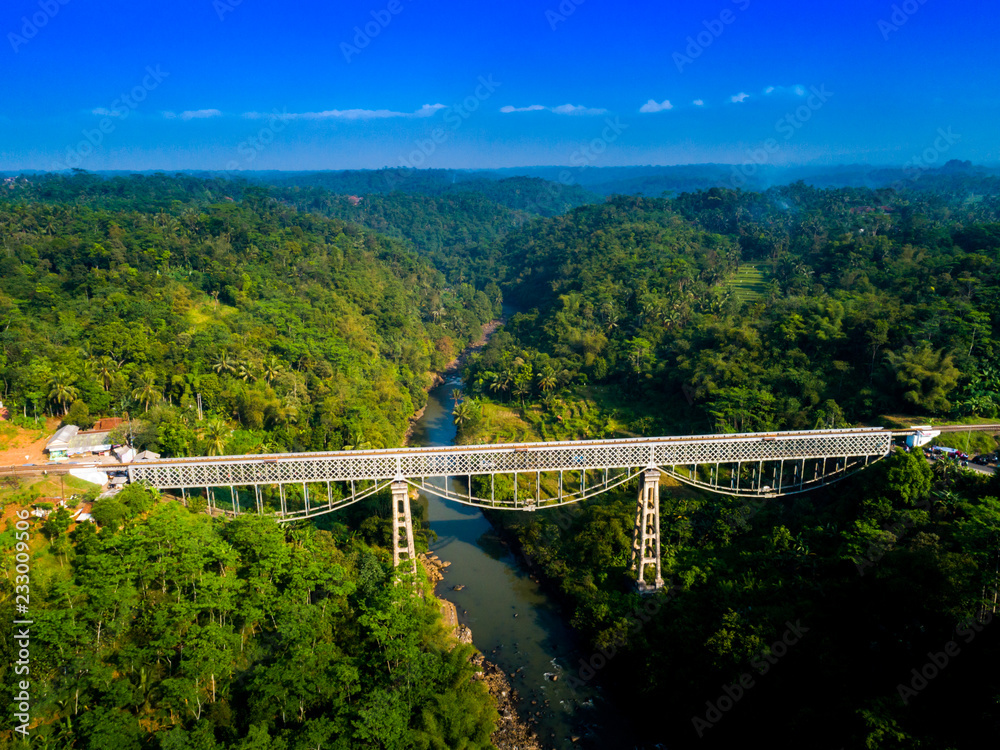Fototapeta premium Scenic Aerial View of Cirahong Bridge, A Double Deck Structure of Metal Railway Bridge and Car Bridge Underneath Made by Dutch Colonial, Manonjaya Tasikmalaya, West Java Indonesia, Asia