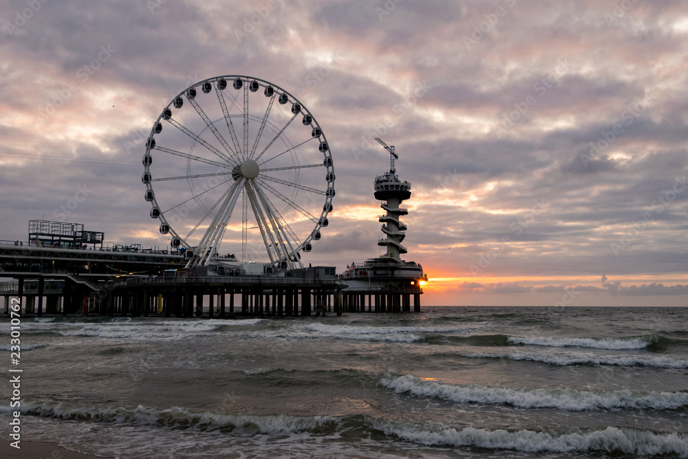 Pier with spinning wheel at the dutch coast near The Hague in Scheveningen, Holland
