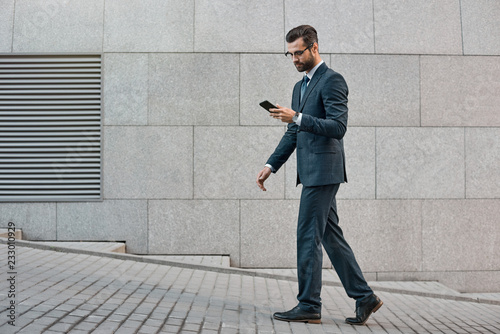 Elegant businessman hand holding and using a smart phone outdoors