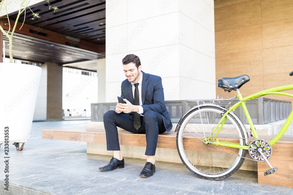 Fototapeta premium Businessman Checking E-Mail On Mobile Phone In City