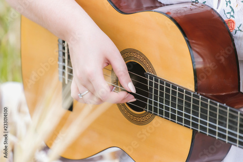 Woman playing guitar, handing the strings