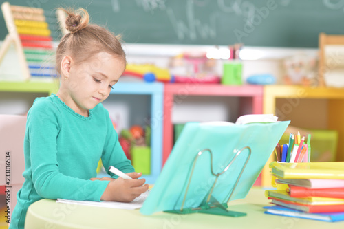 Portrait of a cute schoolgirl doing homework