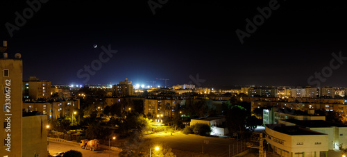Panorama of city neighborhood at evening with new moon