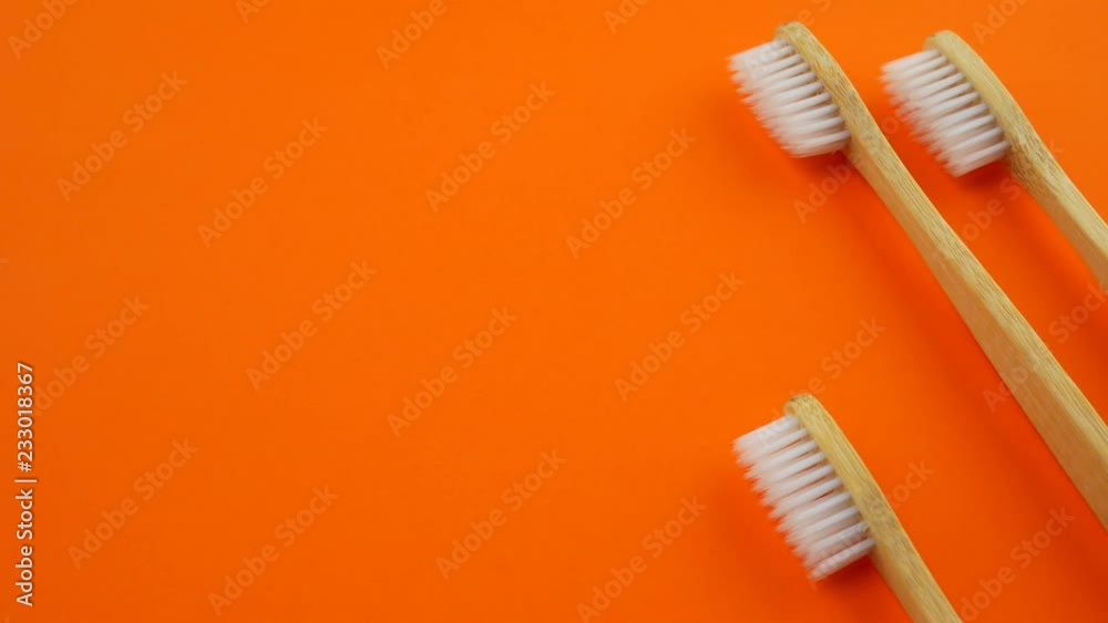 White wooden toothbrushes on orange background White wooden toothbrushes on orange background