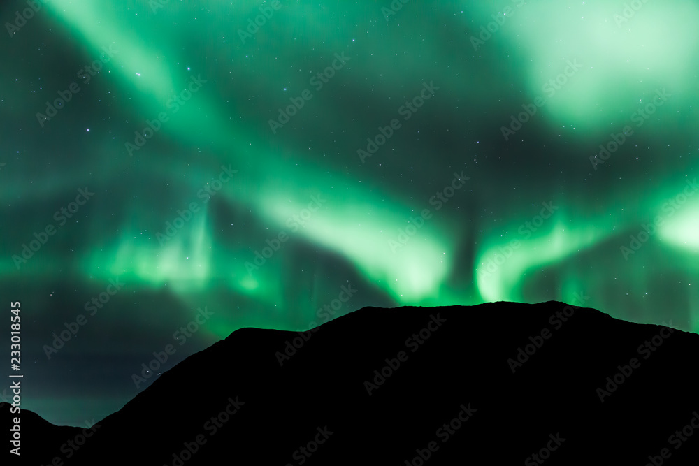 Amazing northern lights in North Norway (Kvaloya), mountains in the background