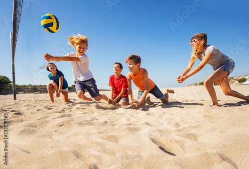 Boy making bump pass during beach volleyball game