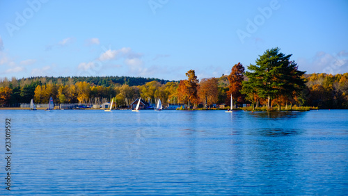 Yachts on a lake with colourful autumn trees
