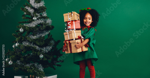 Smiling kid holding a pile of gift boxes