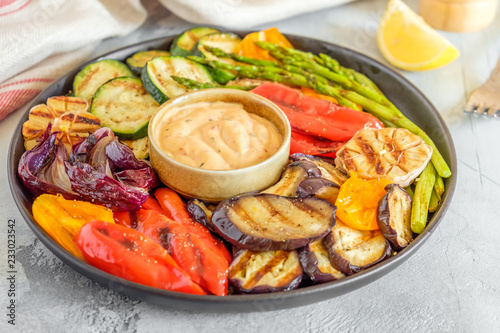 Grilled vegetables on a plate with sauce © tbralnina