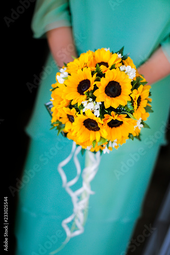 Fototapeta Naklejka Na Ścianę i Meble -  Bouquet di girasoli, tenuto in mano da una sposa  vestita color turchese