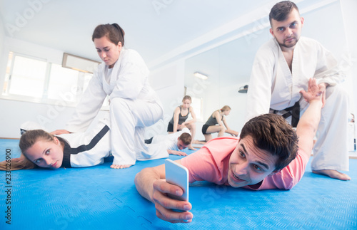 trainees making selfies while sparring in pairs in taekwondo class