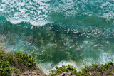 Top view of green and blue Indian ocean washing the cliff in Bali island, Indonesia