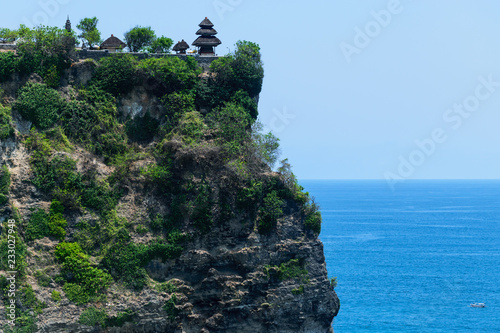 Pura luhur uluwatu temple on the cliff with beautiful view of blue Indian ocean in Bali, Indonesia photo