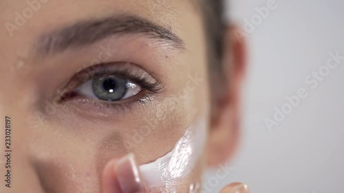Young pretty woman applies face cream on her cheekbones, applying cream in circular motions, skin care, natural cosmetics, face care cream