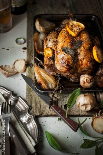 Roast chicken with sage, lemons, onions and garlic photo