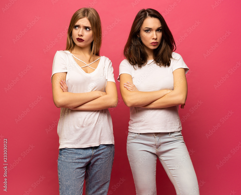 angry young two ladies standing over pink background angry young two ladies standing over pink background
