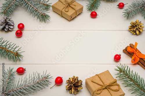 Christmas composition. Christmas gifts, fir tree branches on white wooden background. Flat lay, frame.