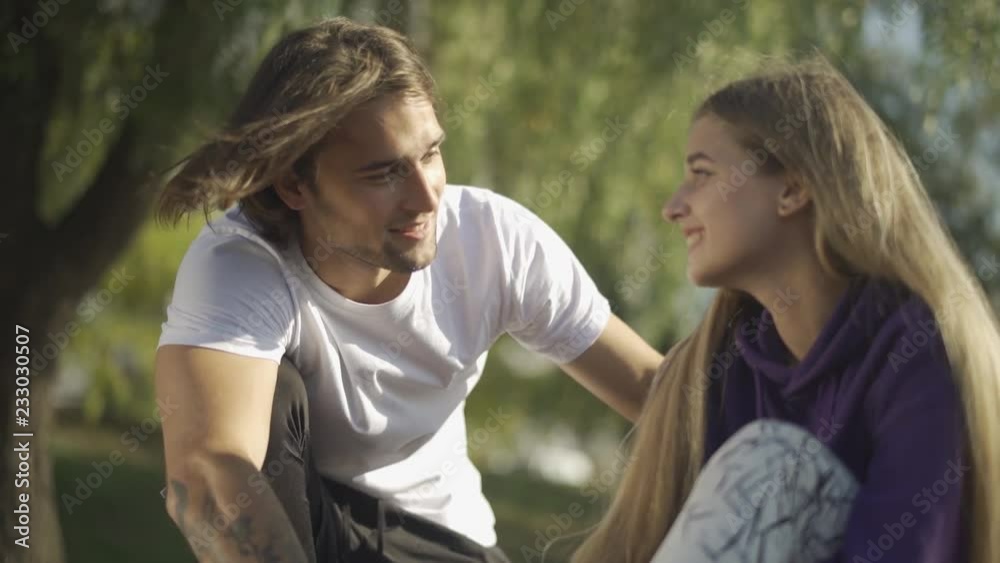 Couple of beautiful people are talking sitting outdoors Couple of beautiful people are talking sitting outdoors