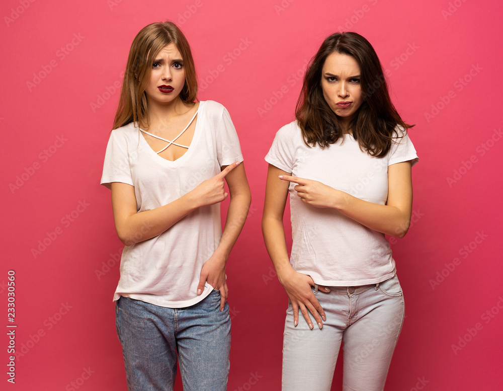 angry young two ladies standing over pink background angry young two ladies standing over pink background