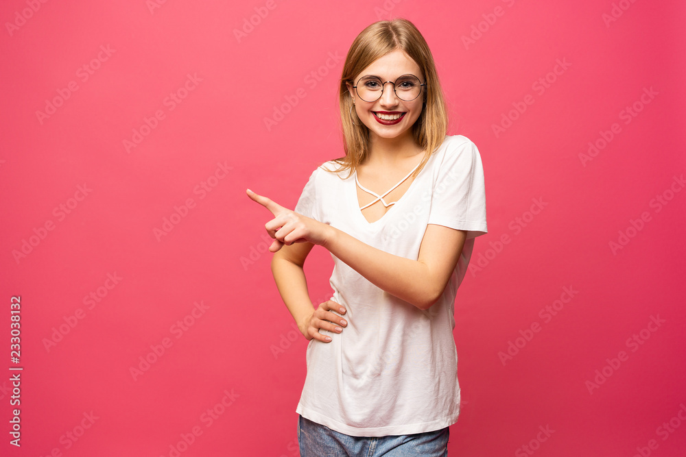 Photo of happy young woman standing isolated over pink background. Looking camera showing copyspace pointing. Photo of happy young woman standing isolated over pink background. Looking camera showing copyspace pointing.