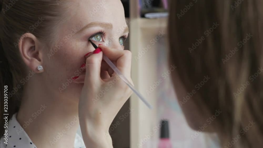 Extreme close up young redhead girl with freckles creating trendy stylish make up look by eyeshadows brush mua artist Extreme close up young redhead girl with freckles creating trendy stylish make up look by eyeshadows brush mua artist