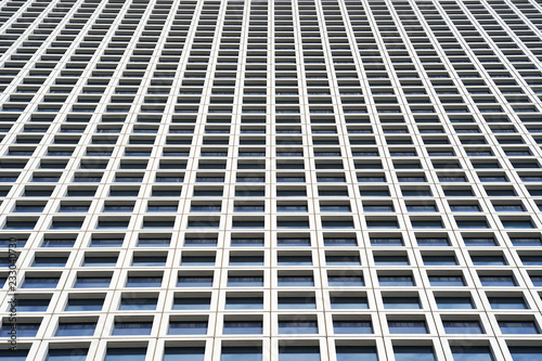 Bottom view glass grey square Windows of modern city business building skyscraper. Receding perspective, movement forward and up. Bottom view of office building window close up.