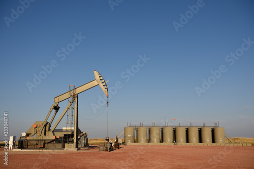 Crude oil well site with pump jack and production storage tanks, Powder River Basin, Wyoming, USA