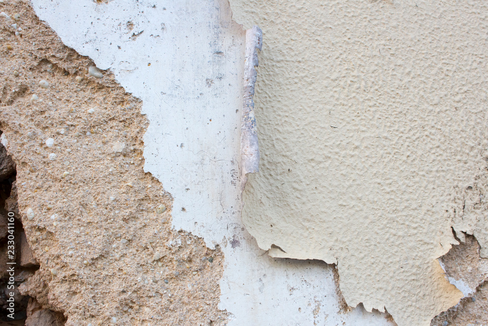 Old and damaged adobe wall with several layers of paint peeling off. Rustic background or texture with copy space. Old and damaged adobe wall with several layers of paint peeling off. Rustic background or texture with copy space.
