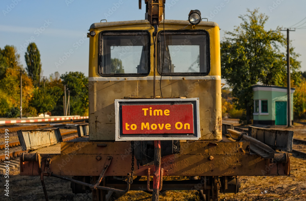 Front part of freight railway motor car (speeder, draisine) with yellow cabin, plate with inscription Time to Move On in the foreground