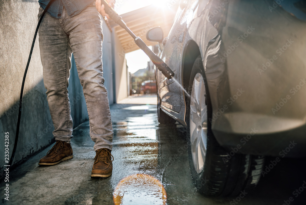 Fototapeta premium Men washing his car with pressure washer