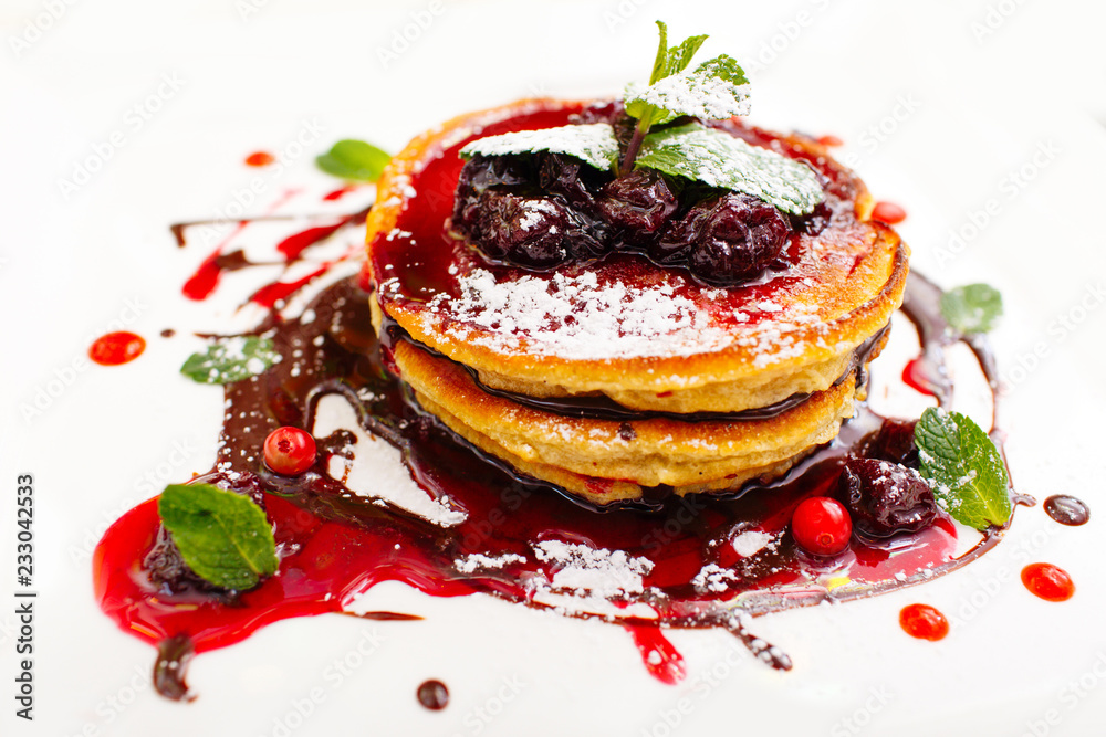 Pancakes with berries and maple syrup isolated in white Pancakes with berries and maple syrup isolated in white