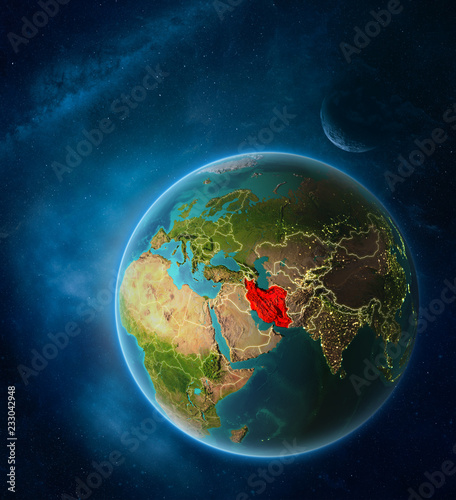 Planet Earth with highlighted Iran in space with Moon and Milky Way. Visible city lights and country borders.