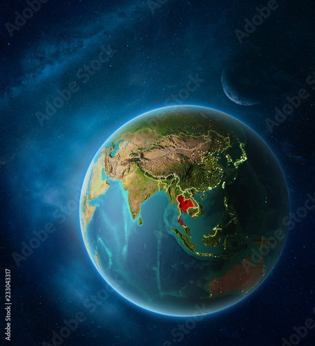 Planet Earth with highlighted Thailand in space with Moon and Milky Way. Visible city lights and country borders.