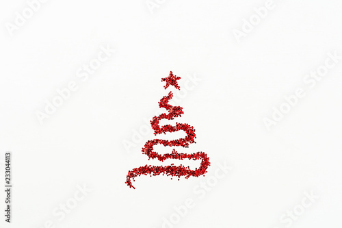 Christmas fir tree symbol made of red glitter sparkles tinsel isolated on white background. Flat lay, top view Christmas, New Year, Winter creative concept.