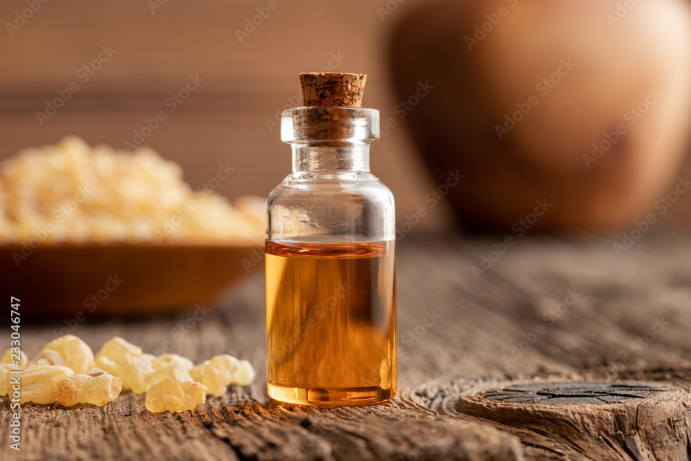 A bottle of frankincense essential oil with frankincense crystals A bottle of frankincense essential oil with frankincense crystals