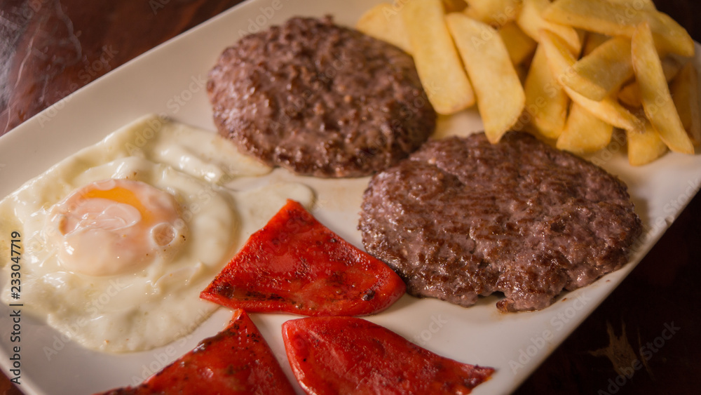 Fried egg with hamburguers, red pepper and chips