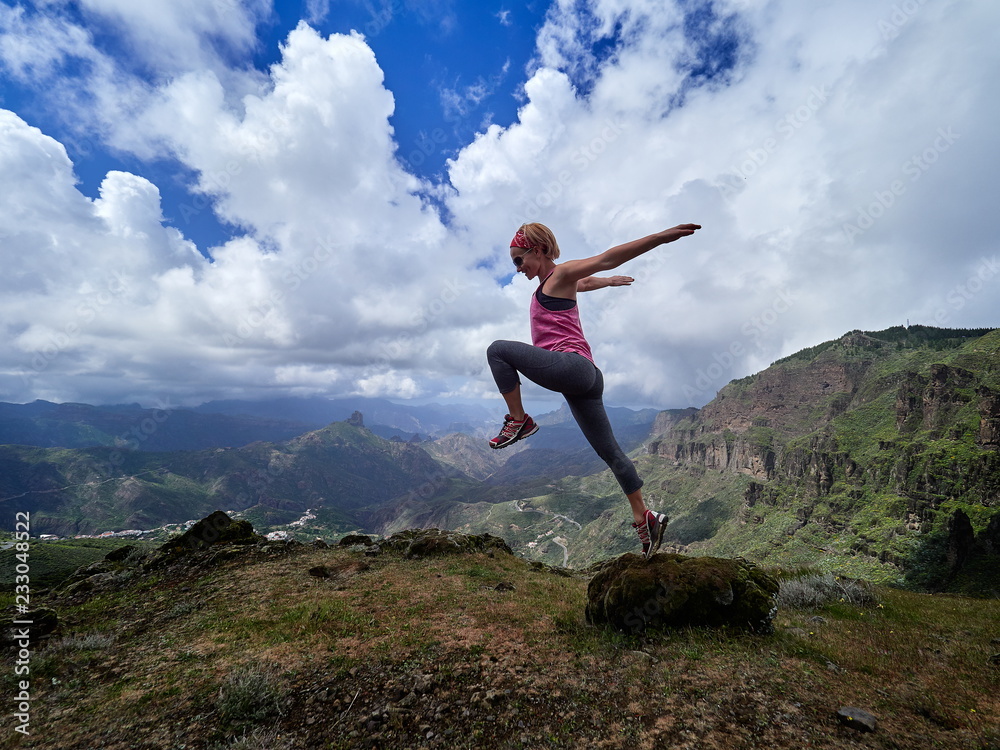 young happy woman jumping on top of the mountain young happy woman jumping on top of the mountain