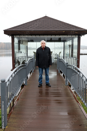 Elderly man on wooden bridge